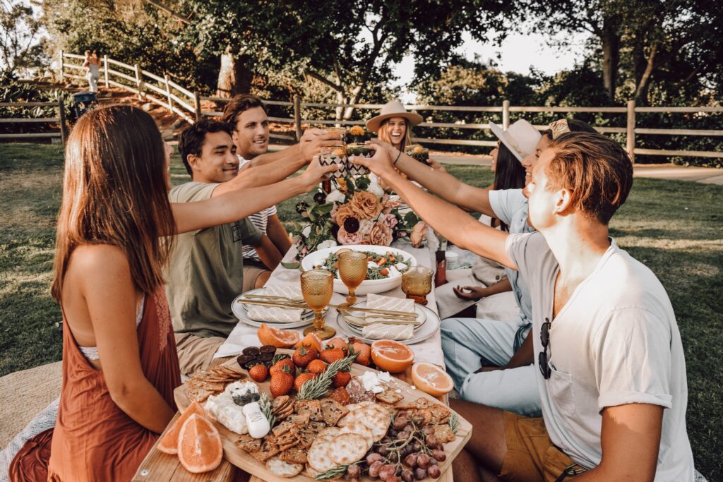 Bilden visar en grupp människor som har fest utomhus. Vaxdukar är ett praktiskt inslag på fester och kalas.